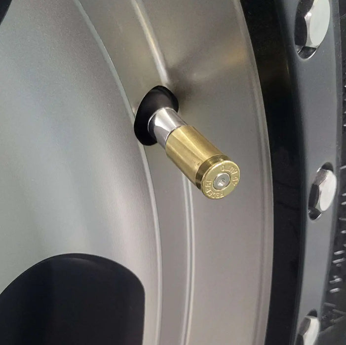 45 brass bullet casing valve stem caps closeup installed on aluminum rim