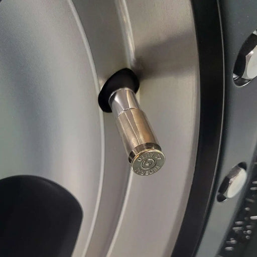 45 acp bullet casing valve stem caps in nickel color installed on aluminum wheel