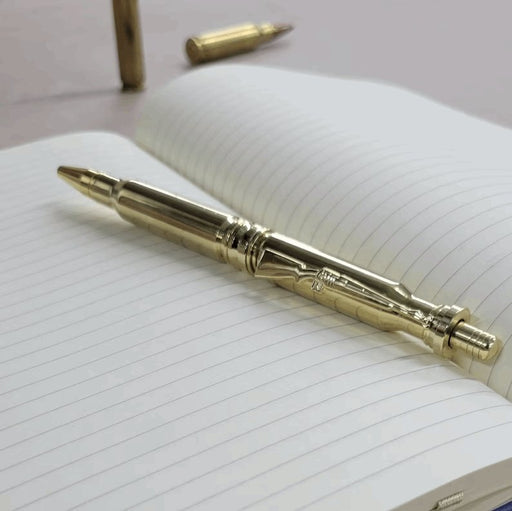 Polished .308 Bullet Click Pen sitting on notepad