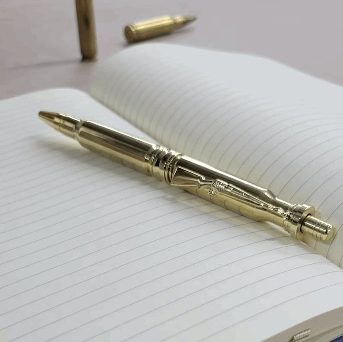 Polished .308 Bullet Click Pen sitting on notepad