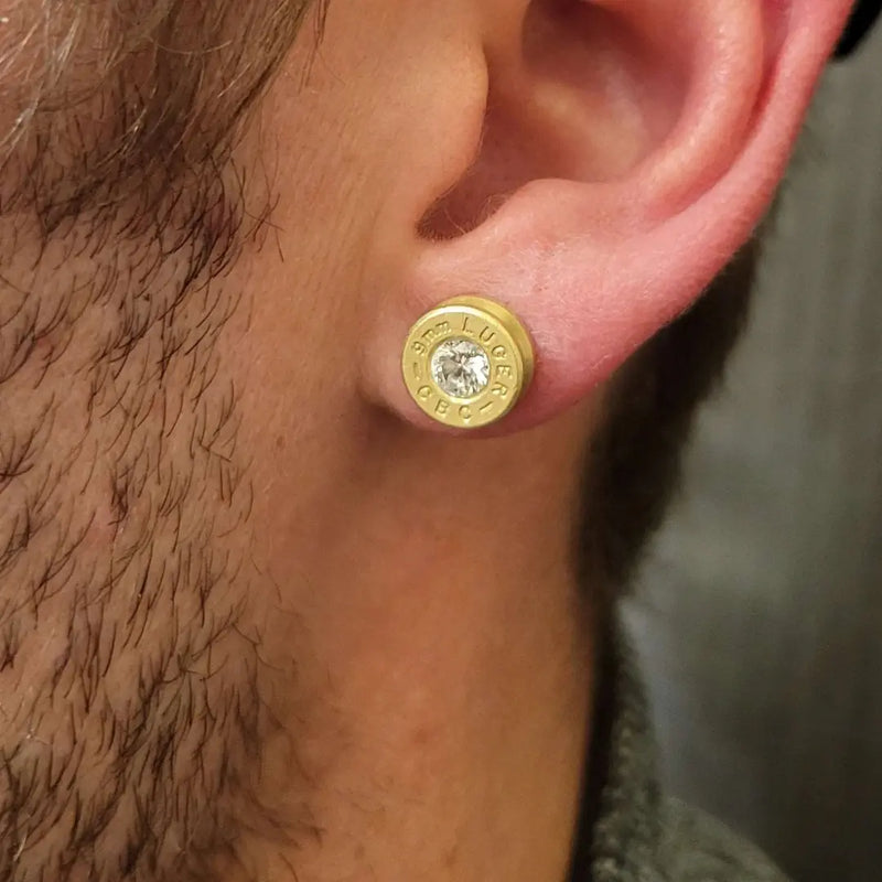 9mm bullet casing stud diamond earring closeup of mans ear wearing it.